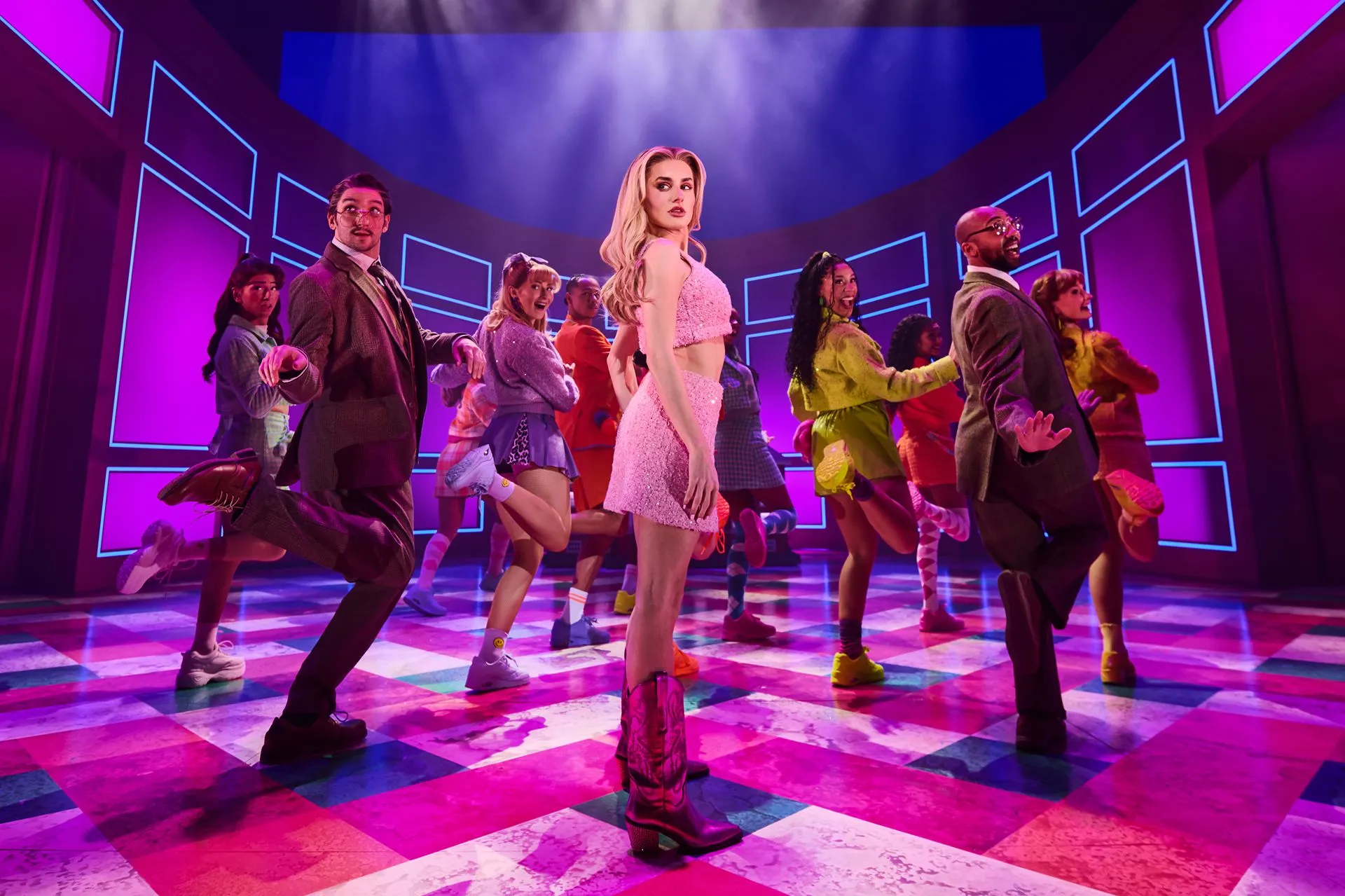 Amber Davies as Elle Woods in pink sequins leads the Harvard students in a high-kicking dance number